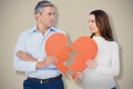 Composite image of couple holding broken heart shape paper Royalty Free Stock Photo