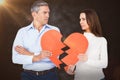 Composite image of couple holding broken heart shape paper Royalty Free Stock Photo