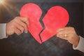 Composite image of couple holding a broken paper heart Royalty Free Stock Photo