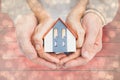 Composite image of couple holding small model house in hands Royalty Free Stock Photo