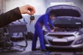 Composite image of couple receiving car keys by a dealer