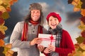 Composite image of couple smiling and holding gift Royalty Free Stock Photo