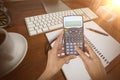 Composite image of cropped hands of businesswoman using calculator Royalty Free Stock Photo