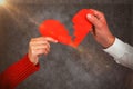 Composite image of cropped hands of couple holding cracked red heart shape