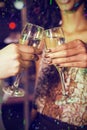 Composite image of cropped image of hand toasting champagne glasses