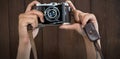 Composite image of cropped image of hands holding camera Royalty Free Stock Photo