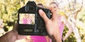 Composite image of cropped image of hands holding camera Royalty Free Stock Photo