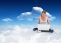 Composite image of cross-legged woman using a laptop Royalty Free Stock Photo