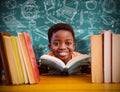 Composite image of cute boy reading book in library Royalty Free Stock Photo