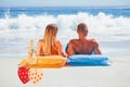 Composite image of cute couple in swimsuit sunbathing together