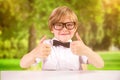 Composite image of cute pupil showing thumbs up