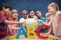 Composite image of cute pupils and teacher looking at globe in library Royalty Free Stock Photo