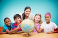 Composite image of cute pupils and teacher looking at globe in library Royalty Free Stock Photo