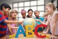 Composite image of cute pupils and teacher looking at globe in library Royalty Free Stock Photo