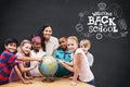 Composite image of cute pupils and teacher looking at globe in library Royalty Free Stock Photo