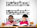 Composite image of cute pupils writing at desk in classroom