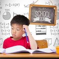 Composite image of cute pupils writing at desk in classroom