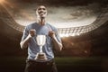 Composite image 3D of happy athlete holding trophy looking up