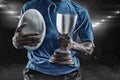 Composite image 3D of mid section of sportsman holding trophy and rugby ball