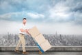 Composite image of delivery man pushing trolley of boxes Royalty Free Stock Photo