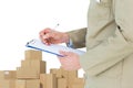 Composite image of delivery man writing on clipboard Royalty Free Stock Photo