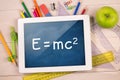 Composite image of digital tablet on students desk Royalty Free Stock Photo