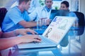 Composite image of doctor typing on keyboard with her team behind Royalty Free Stock Photo