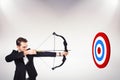 Composite image of elegant businessman shooting bow and arrow Royalty Free Stock Photo