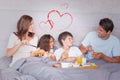 Composite image of family having breakfast in bed