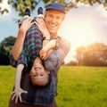 Composite image of father holding his son upside down