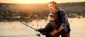 Composite image of father teaching his son fishing Royalty Free Stock Photo