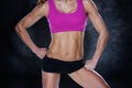Composite image of female bodybuilder posing in pink sports bra and shorts mid section