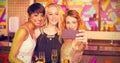 Composite image of female friends taking selfie from mobile phone while having champagne Royalty Free Stock Photo