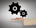 Composite image of female hand presenting cogs and wheels Royalty Free Stock Photo