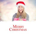 Composite image of festive blonde holding christmas gift Royalty Free Stock Photo