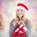 Composite image of festive blonde holding christmas gift and bag Royalty Free Stock Photo