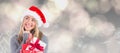 Composite image of festive blonde holding christmas gift and bag Royalty Free Stock Photo