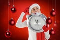 Composite image of festive blonde holding a clock Royalty Free Stock Photo