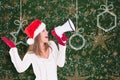 Composite image of festive blonde shouting through megaphone