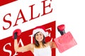 Composite image of festive brunette in boxing gloves holding shopping bags Royalty Free Stock Photo