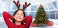 Composite image of festive little girl wearing antlers