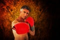 Composite image of fit man punching with boxing gloves Royalty Free Stock Photo