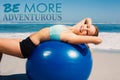 A Composite image of fit woman lying on exercise ball at the beach stretching Royalty Free Stock Photo