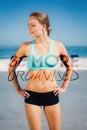 A Composite image of fit woman standing on the beach with hands on hips Royalty Free Stock Photo