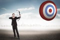 Composite image of focused businessman shooting a bow and arrow Royalty Free Stock Photo