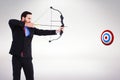 Composite image of focused businessman shooting a bow and arrow Royalty Free Stock Photo