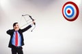 Composite image of focused businessman shooting a bow and arrow Royalty Free Stock Photo