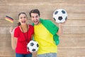 Composite image of football fan couple cheering and smiling at camera Royalty Free Stock Photo