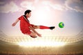 Composite image of football player in red kicking Royalty Free Stock Photo