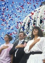 Composite image of four people at a citizenship ceremony superimposed over the U.S. Capitol and balloons